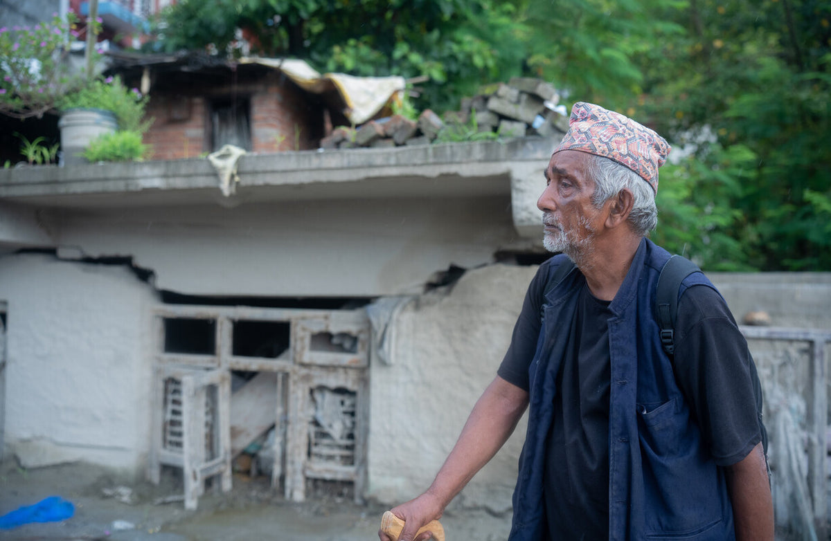 Nepal: Krishna Bahadur Nepali looks at his house damaged by the flood in Devighat Bazaar, Nuwakot. Photo: Sharada Bashyal / Oxfam